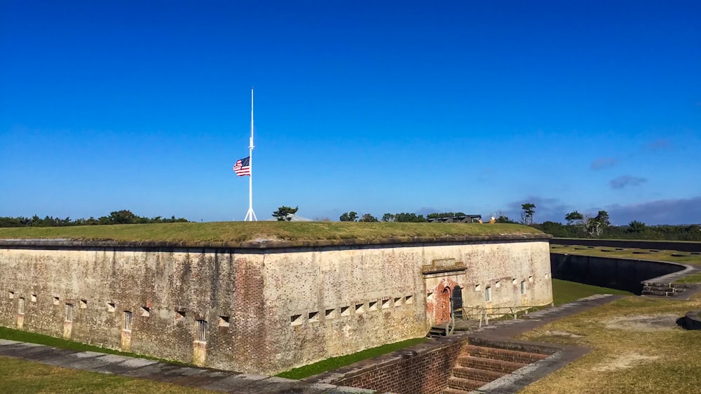 white and red flag on gray concrete wall under blue sky during daytime