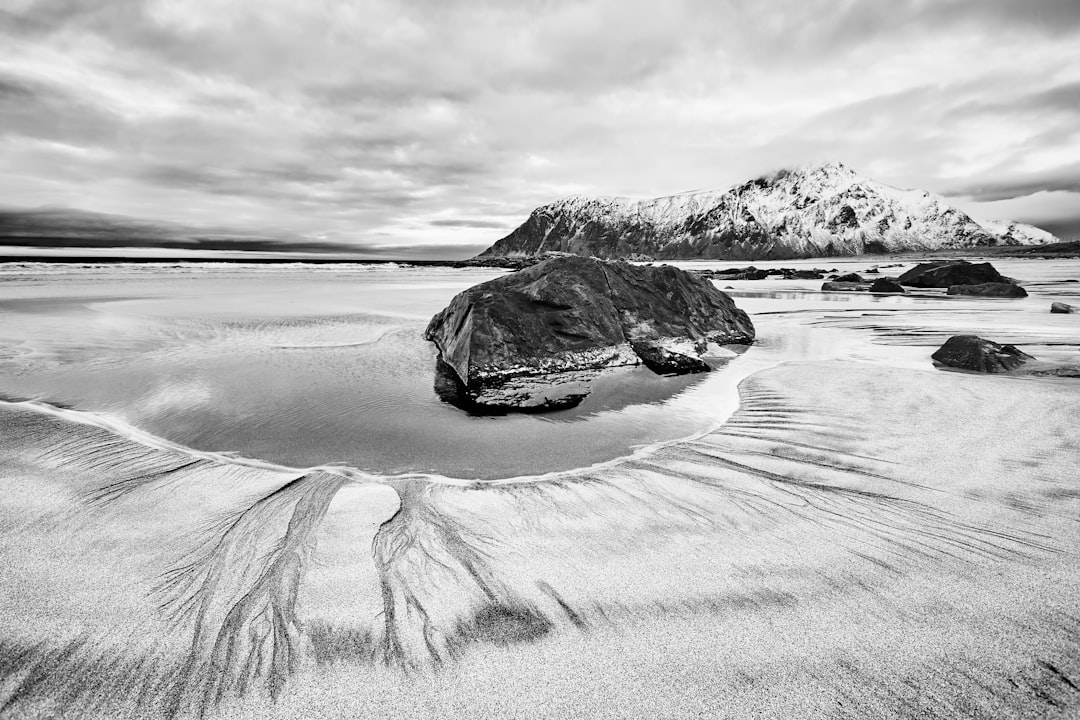 grayscale photo of rock formation on beach