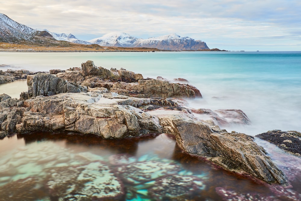 brown rock formation on body of water during daytime