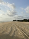brown sand near body of water during daytime