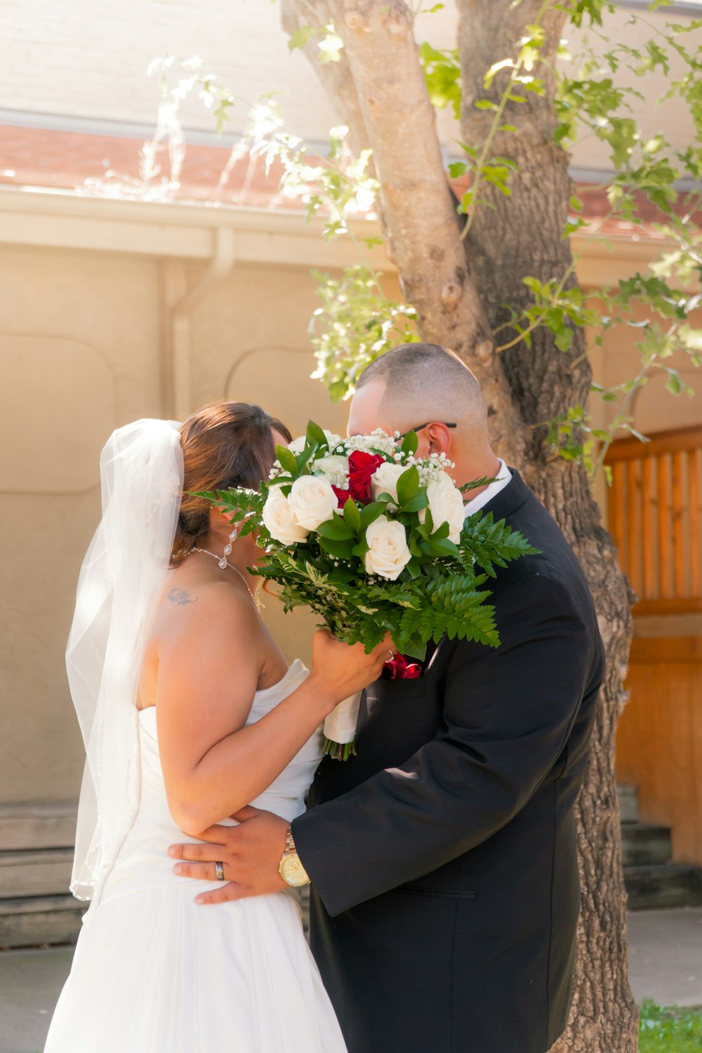 Foto homem no terno preto beijando a mulher no vestido de noiva branco  segurando buquê de flores – Imagem de Casamento grátis no Unsplash