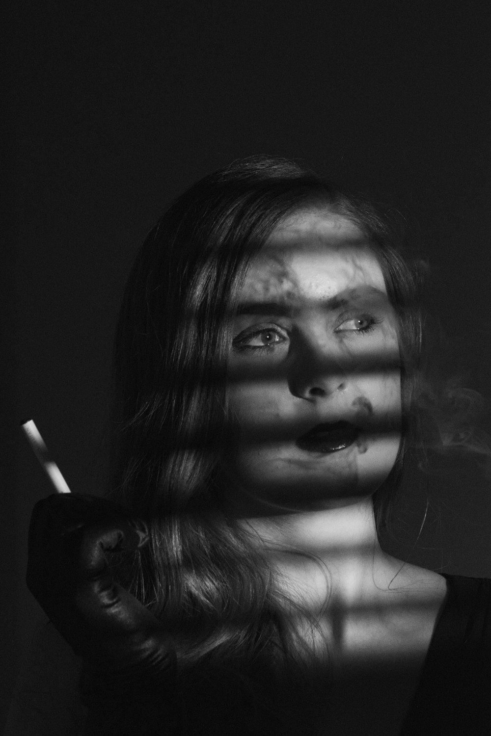 grayscale photo of woman smoking cigarette