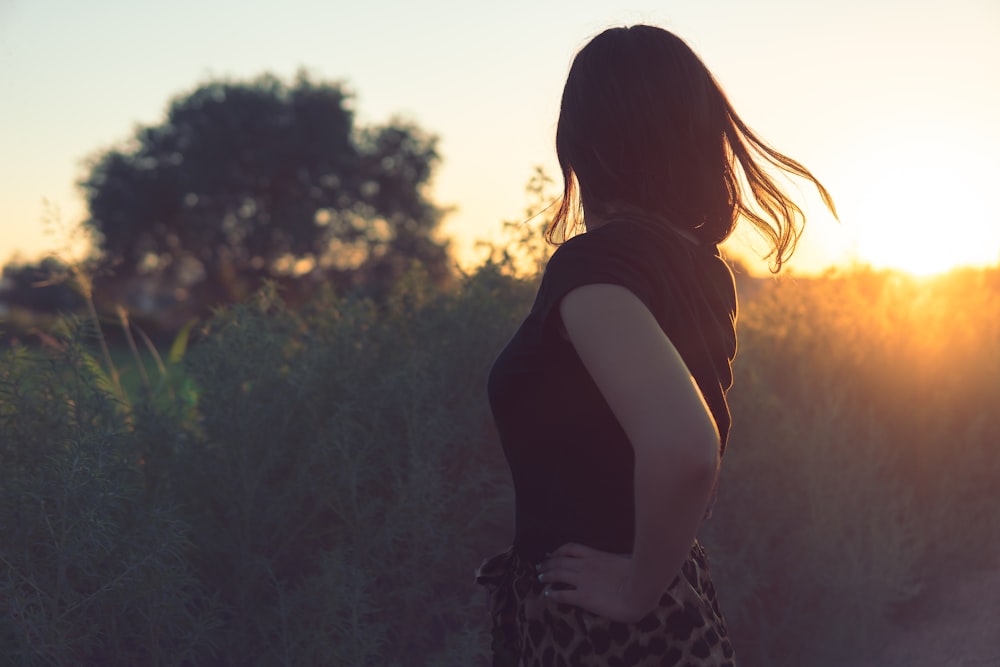 woman in black and white dress standing near green trees during daytime