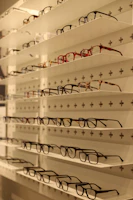 A display of colorful eyeglass frames arranged neatly on a modern shelf.