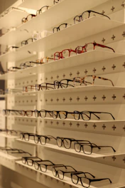 An assortment of designer glasses and stylish hats neatly arranged on a shelf.