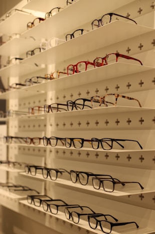 Close-up of high-quality eyeglass frames displayed on a wooden shelf.