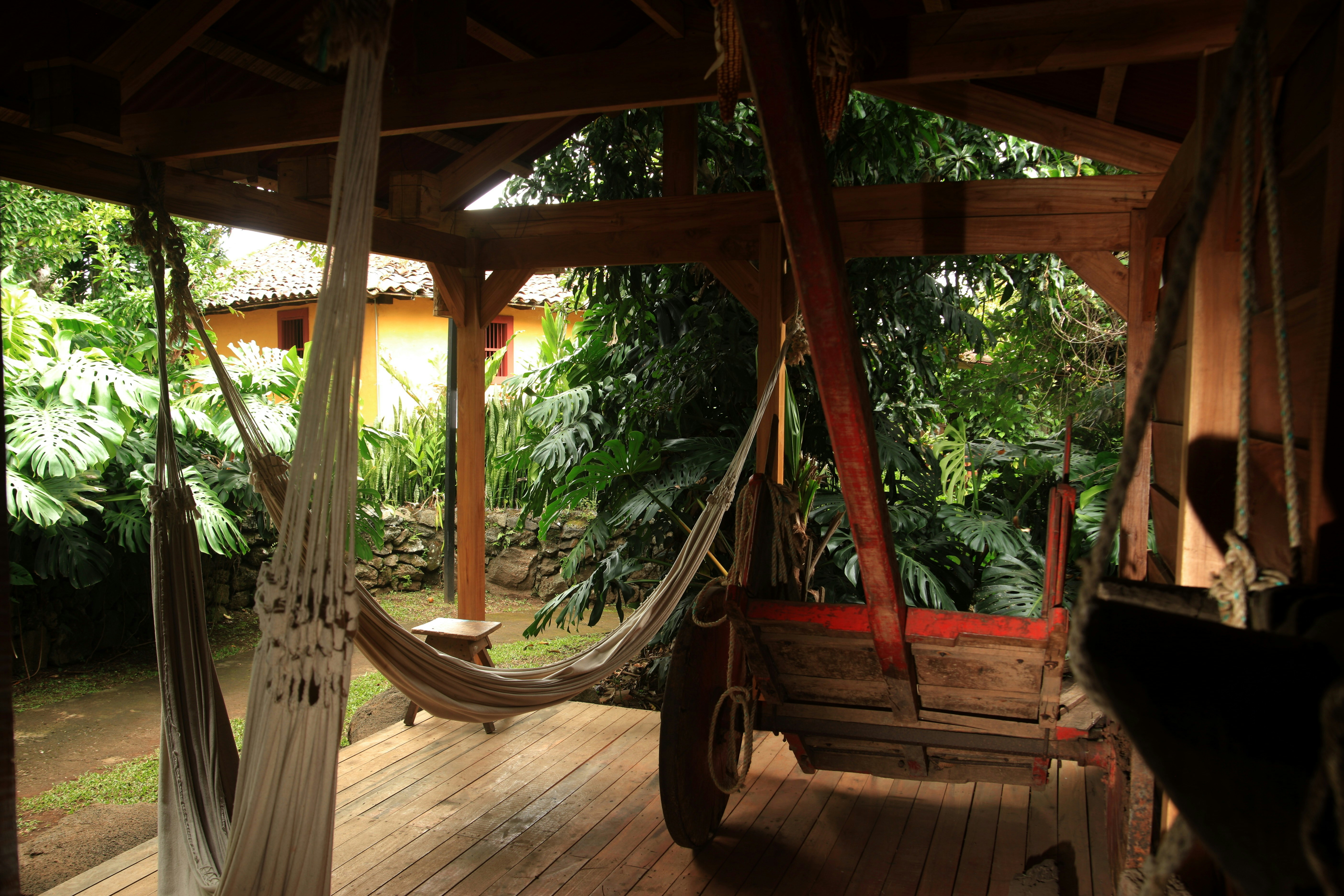Small hut for coffee plantation workers to rest, with hammocks and an oxcart for carrying coffee. In the background, the plantation owners house. Conserved house of the 19th century 