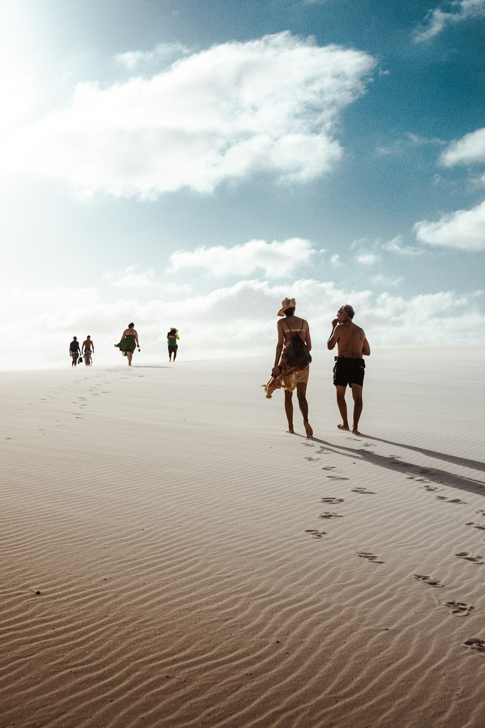 Gente caminando sobre arena blanca durante el día