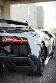 Rear diffuser and spoiler details on a muscle car in an industrial street environment.