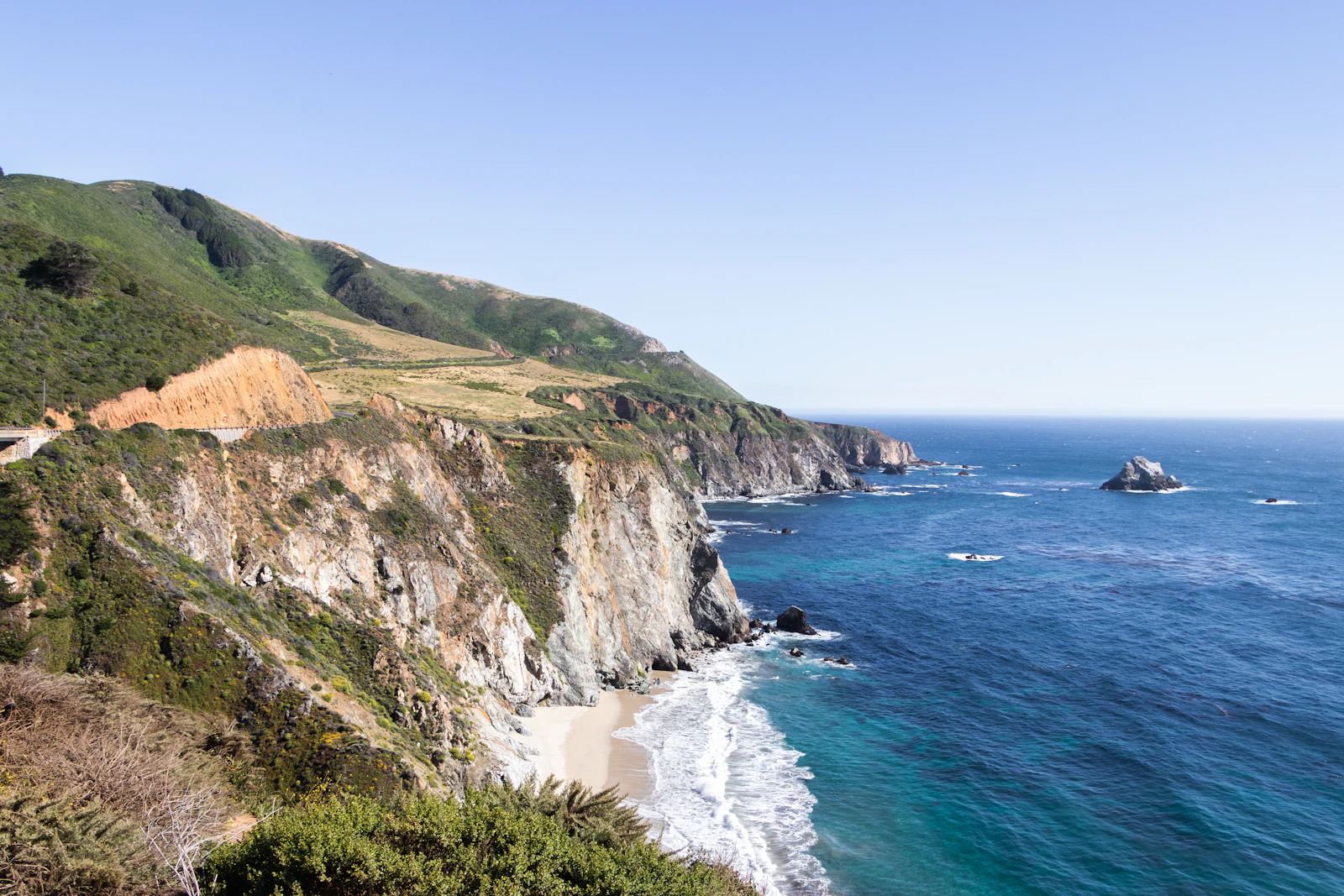 Sunlit cliffs and turquoise water along California's Big Sur coast