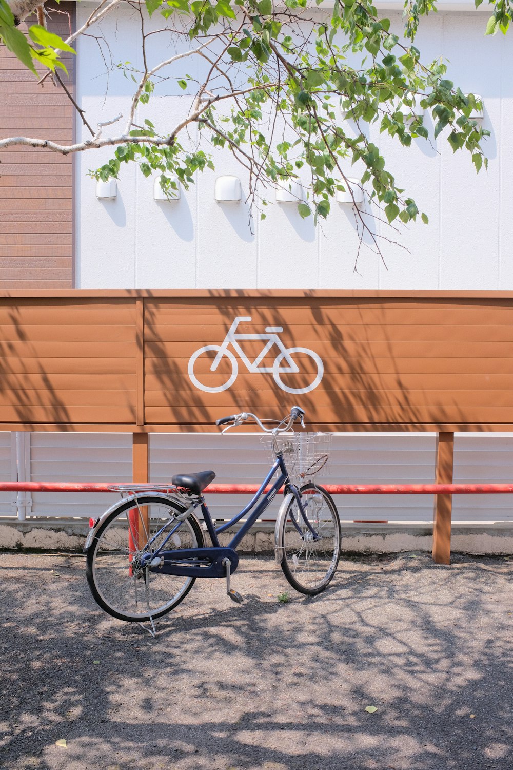 Bicicleta urbana negra estacionada junto a un banco de madera marrón