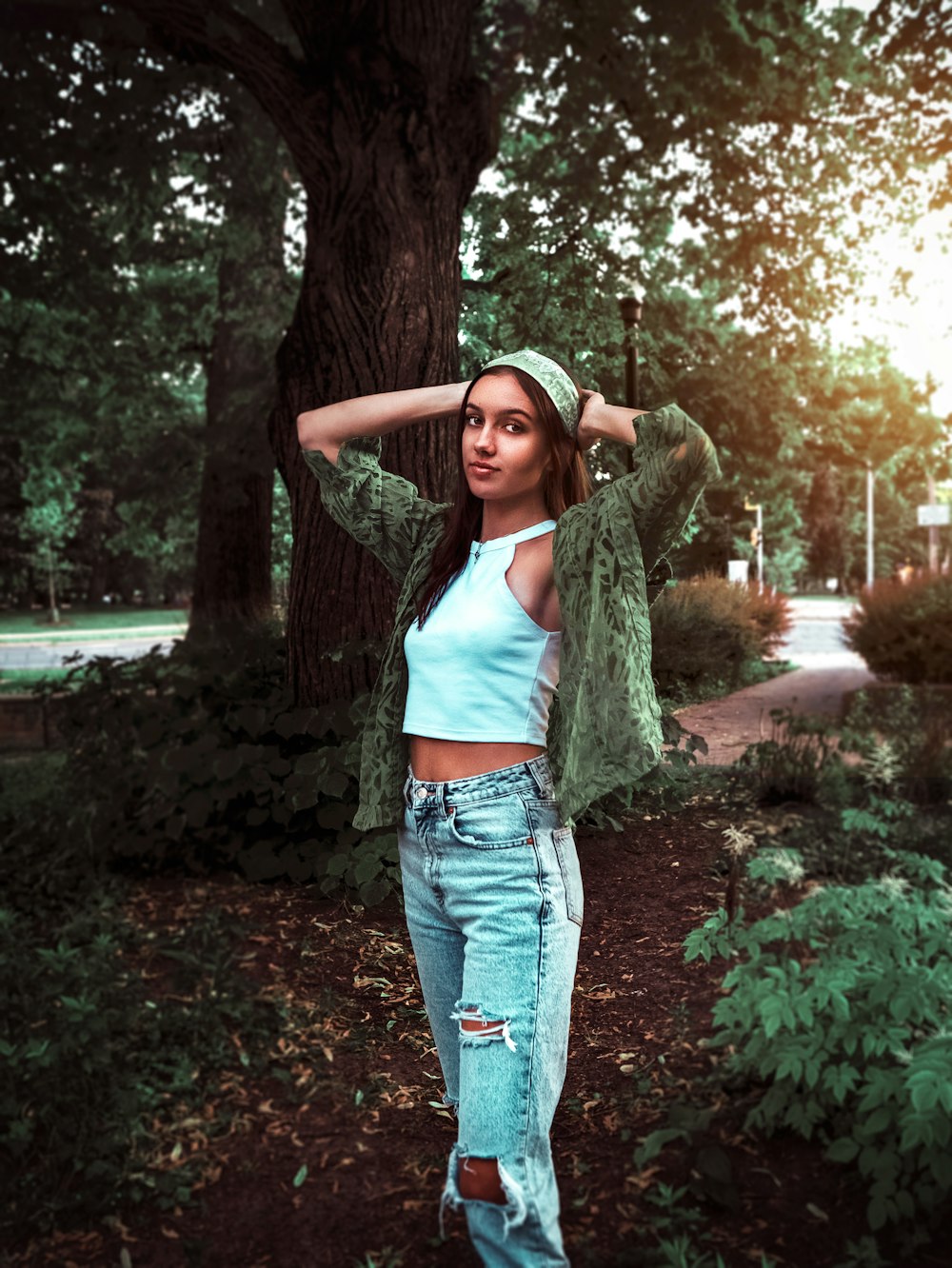 woman in blue denim jeans standing near tree during daytime