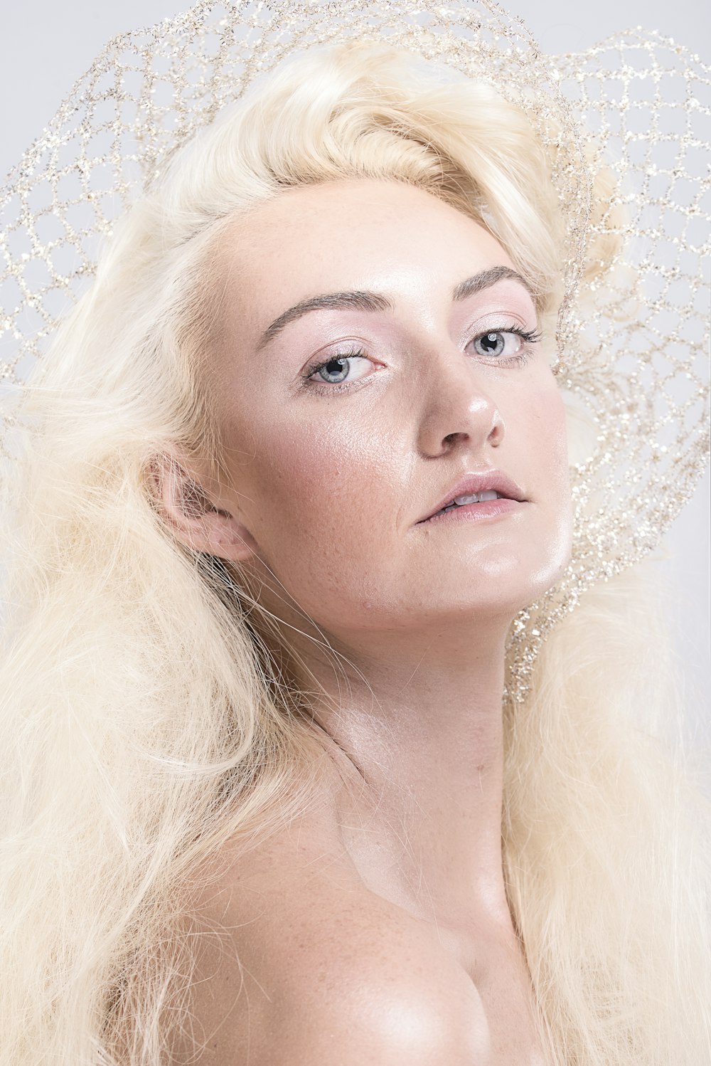 Frau mit blonden Haaren und weißen Perlenohrringen