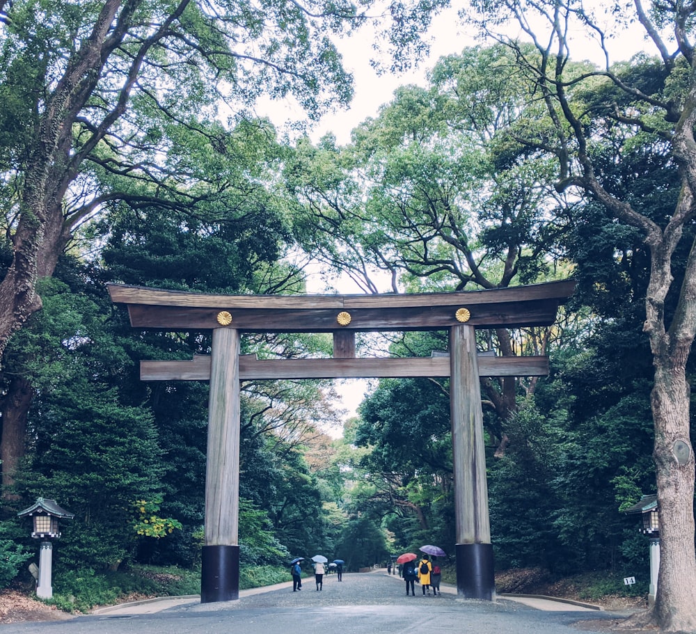 people sitting on bench under brown wooden arch