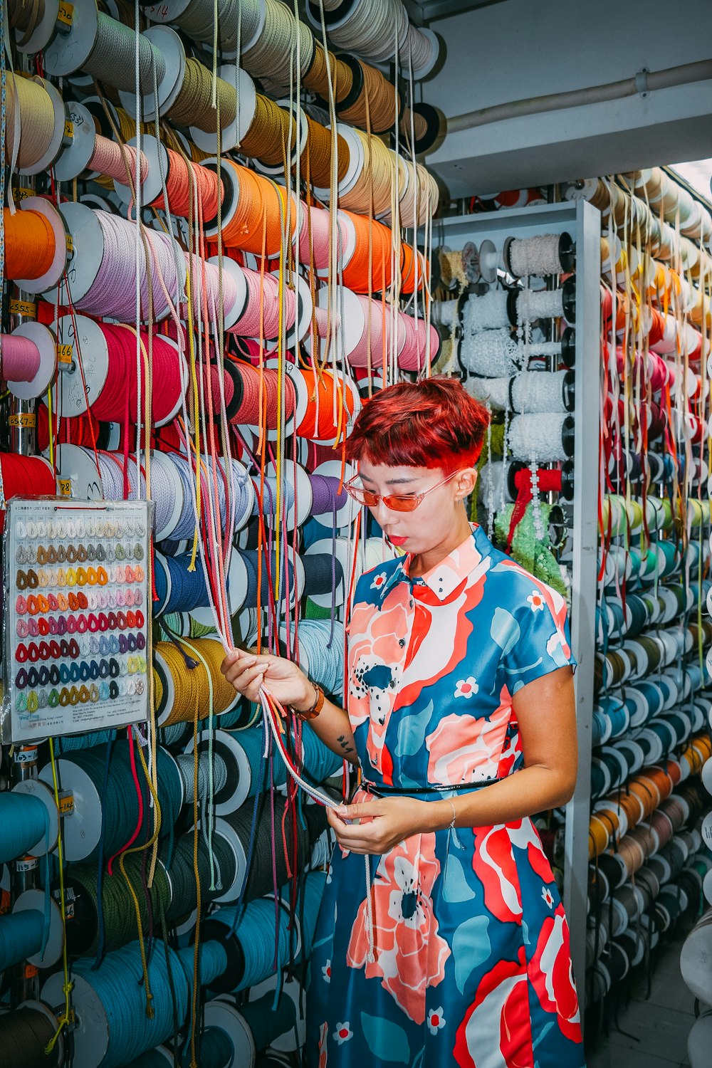 woman in blue and white floral shirt standing near red and blue plastic cups