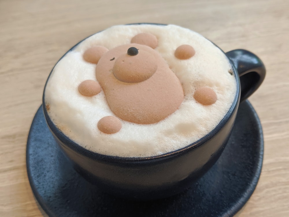 white and brown ice cream on black ceramic cup