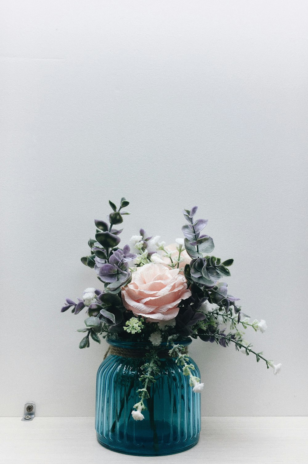 pink roses in blue glass vase