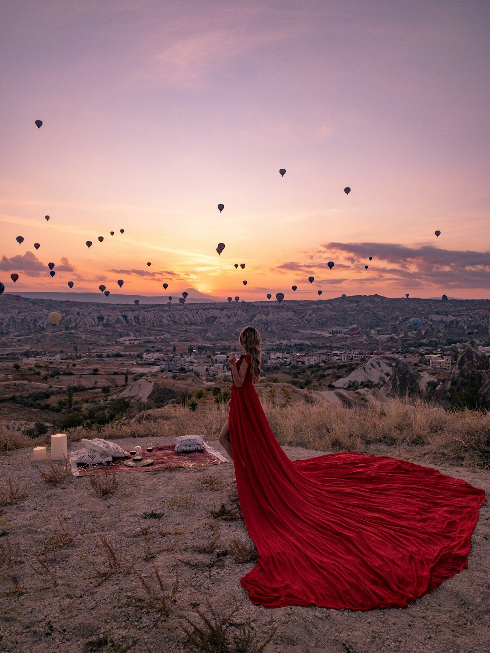 donna in vestito rosso in piedi su campo marrone durante il giorno