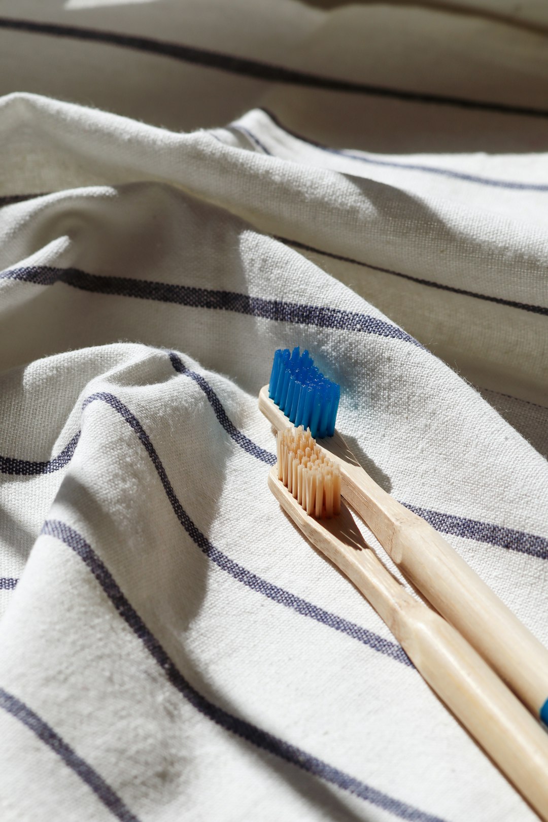 brown and blue toothbrush on white textile