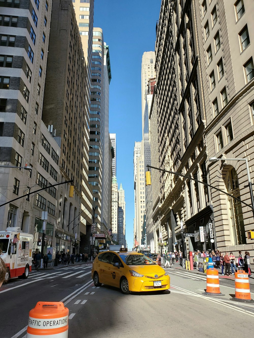 cars on road between high rise buildings during daytime