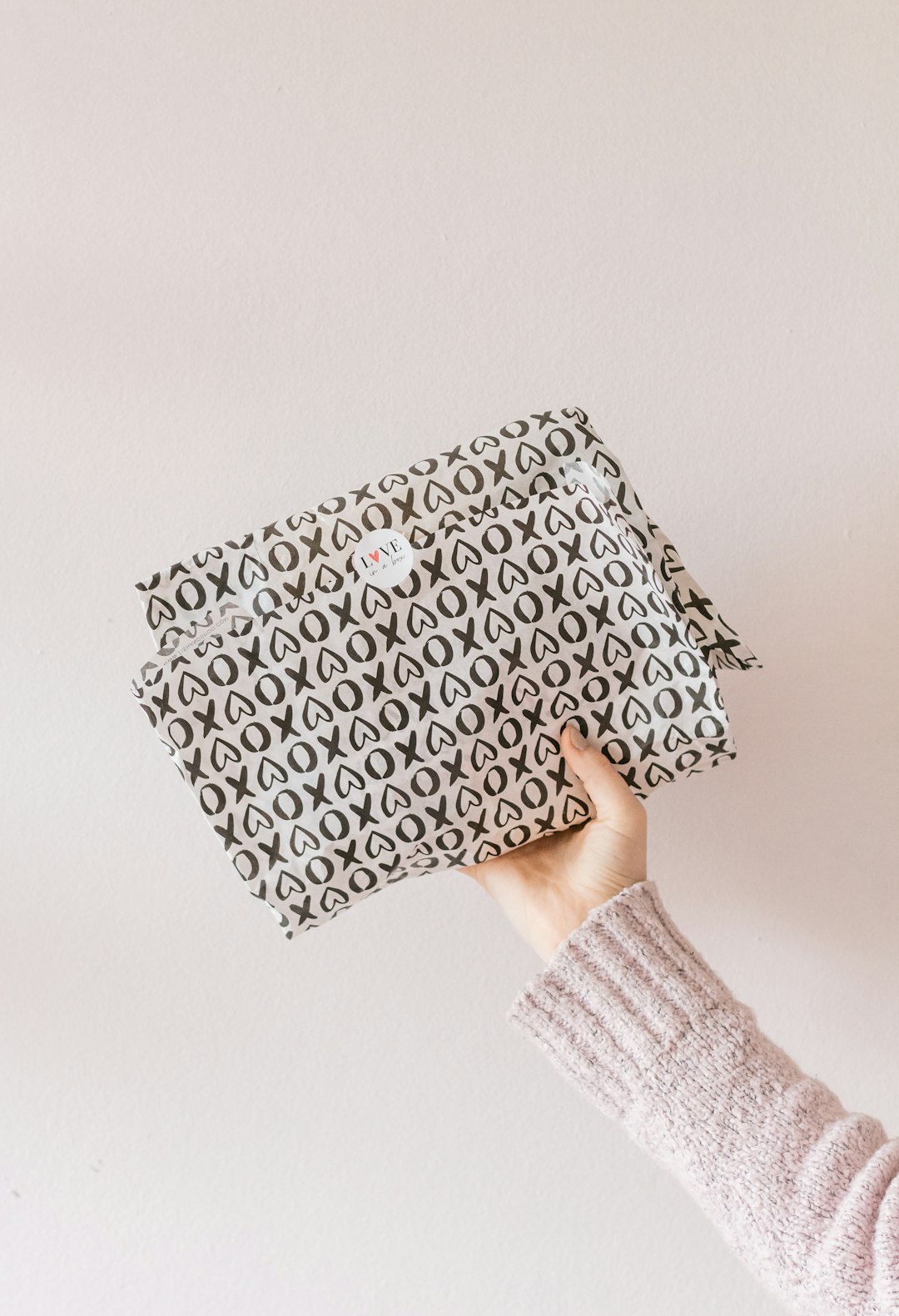 person holding black and white polka dot throw pillow