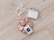 A set of pearl hair clips, a bar of natural handcrafted soap, and a beige satin scrunchie arranged on a light wood surface. The soap is labeled with 'JONK' and mentions scents of guido and eucalyptus.