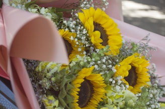 Close-up of a graduation bouquet with bright yellow sunflowers and delicate baby's breath.