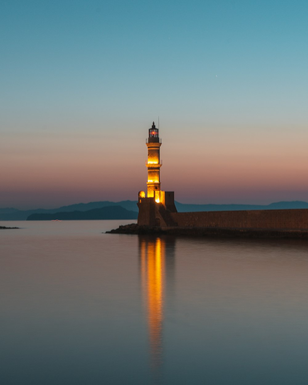 black and white lighthouse on island during sunset