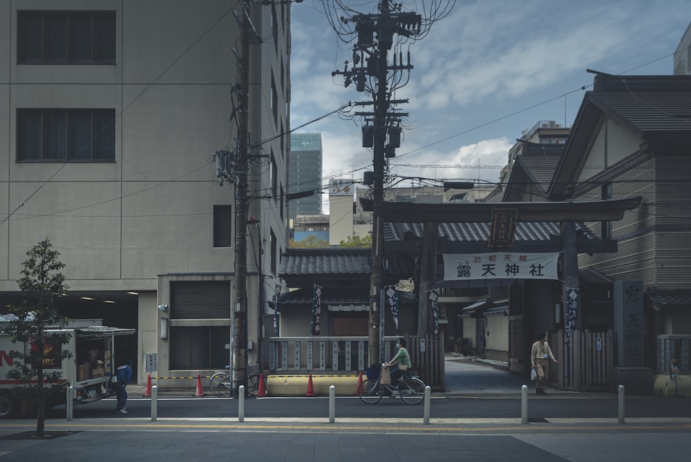 man in yellow jacket and black pants walking on sidewalk during daytime