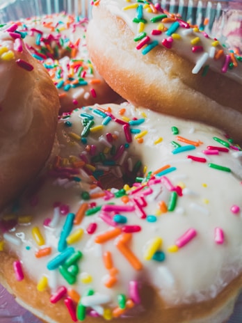 A close-up of freshly made mini donuts with colorful icing.