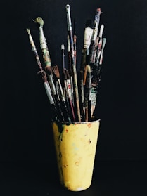 paint brushes in yellow plastic cup
