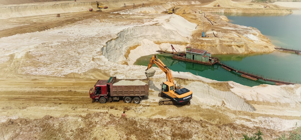 red and blue heavy equipment on brown sand during daytime