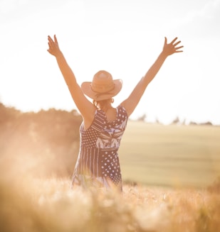 woman in black and white polka dot dress raising her hands