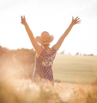 woman in black and white polka dot dress raising her hands