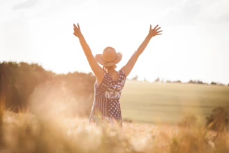 woman in black and white polka dot dress raising her hands