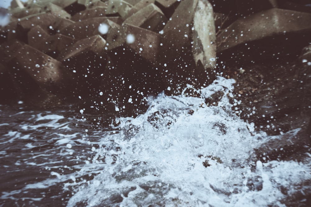 water waves hitting rocks during daytime