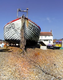 blue and red boat on brown sand during daytime