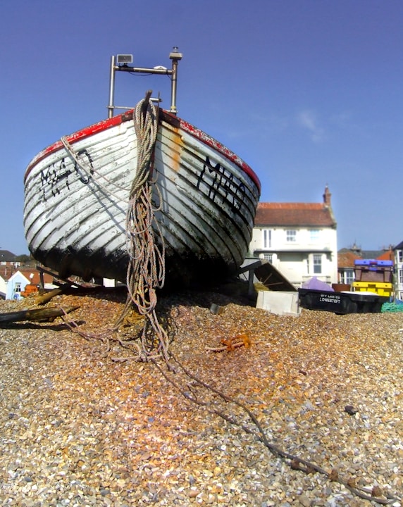 blue and red boat on brown sand during daytime