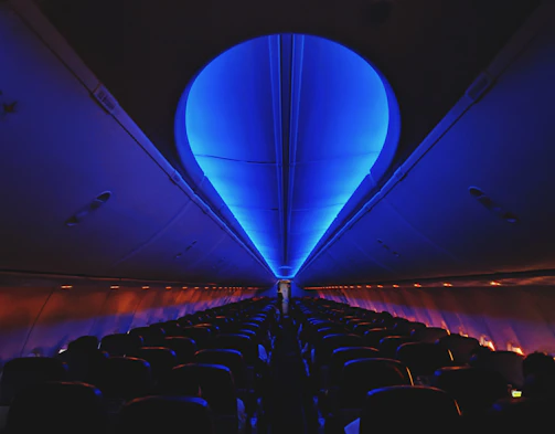 A cozy airplane cabin with passengers settling in for takeoff, soft lighting creating a calm atmosphere.