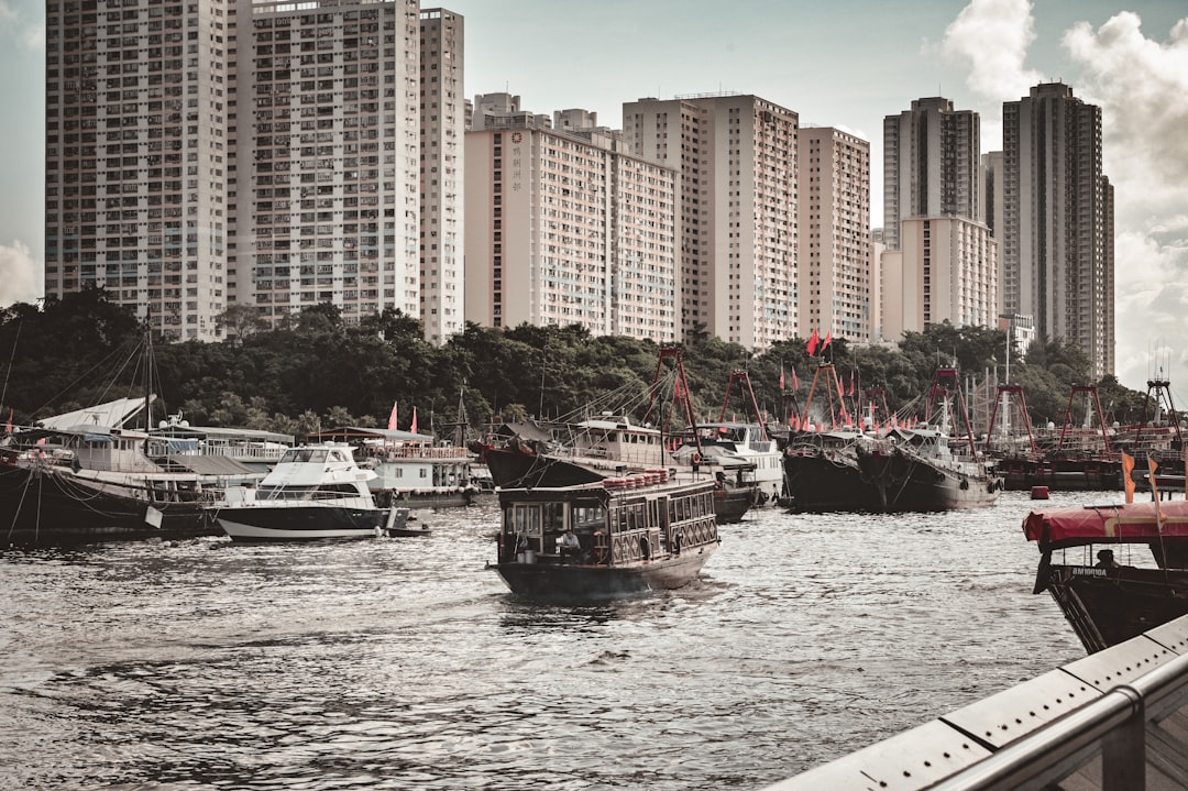 white and black boat on body of water near city buildings during daytime