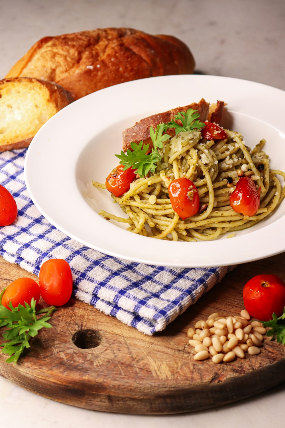 pasta with green and red vegetables on white ceramic plate