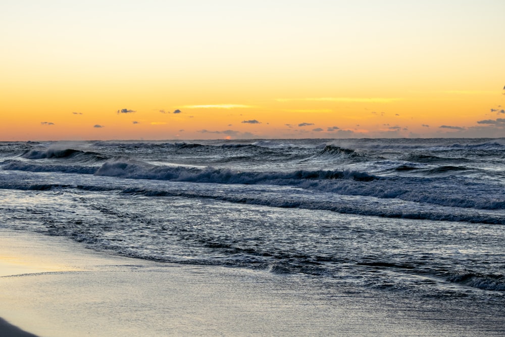 Les vagues de l’océan s’écrasent sur le rivage au coucher du soleil