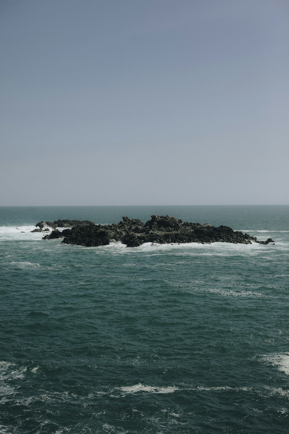 ocean waves crashing on rocks during daytime