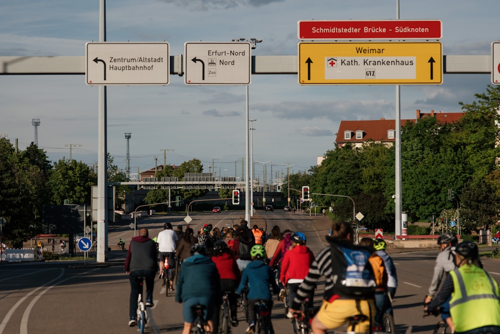 people riding bicycles on road during daytime