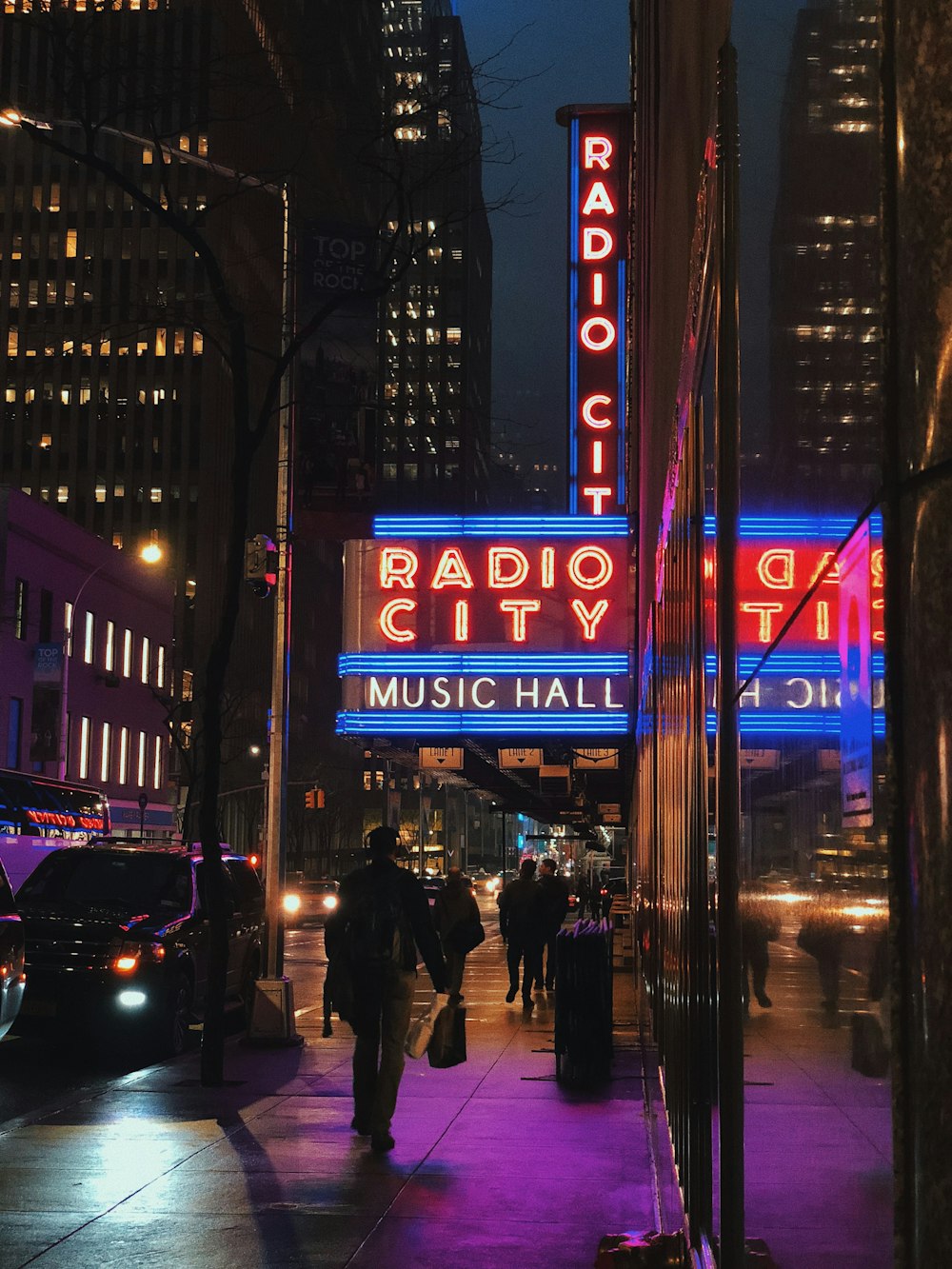 people walking on sidewalk during night time