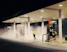 man in yellow jacket standing near gas pump