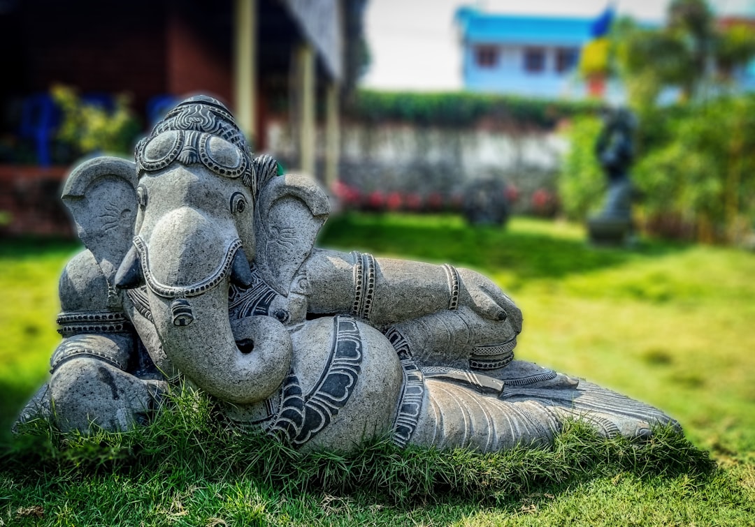 gray elephant figurine on green grass during daytime
