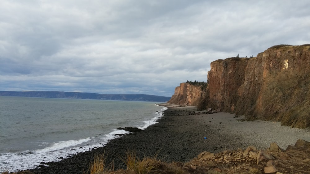 brown rock formation near body of water during daytime