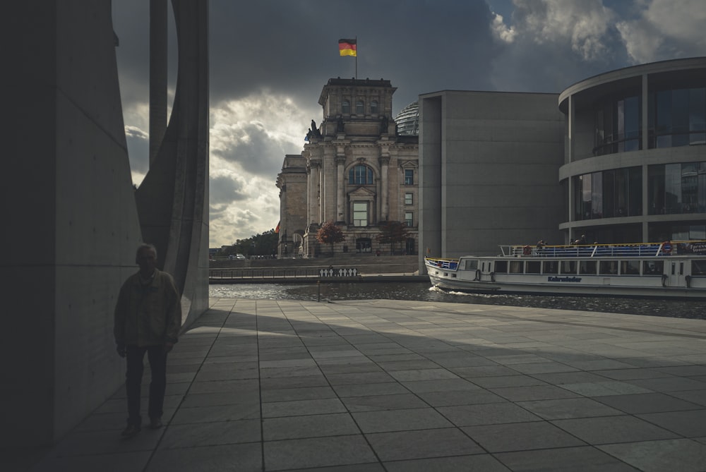 people walking on gray concrete pathway near brown concrete building during daytime