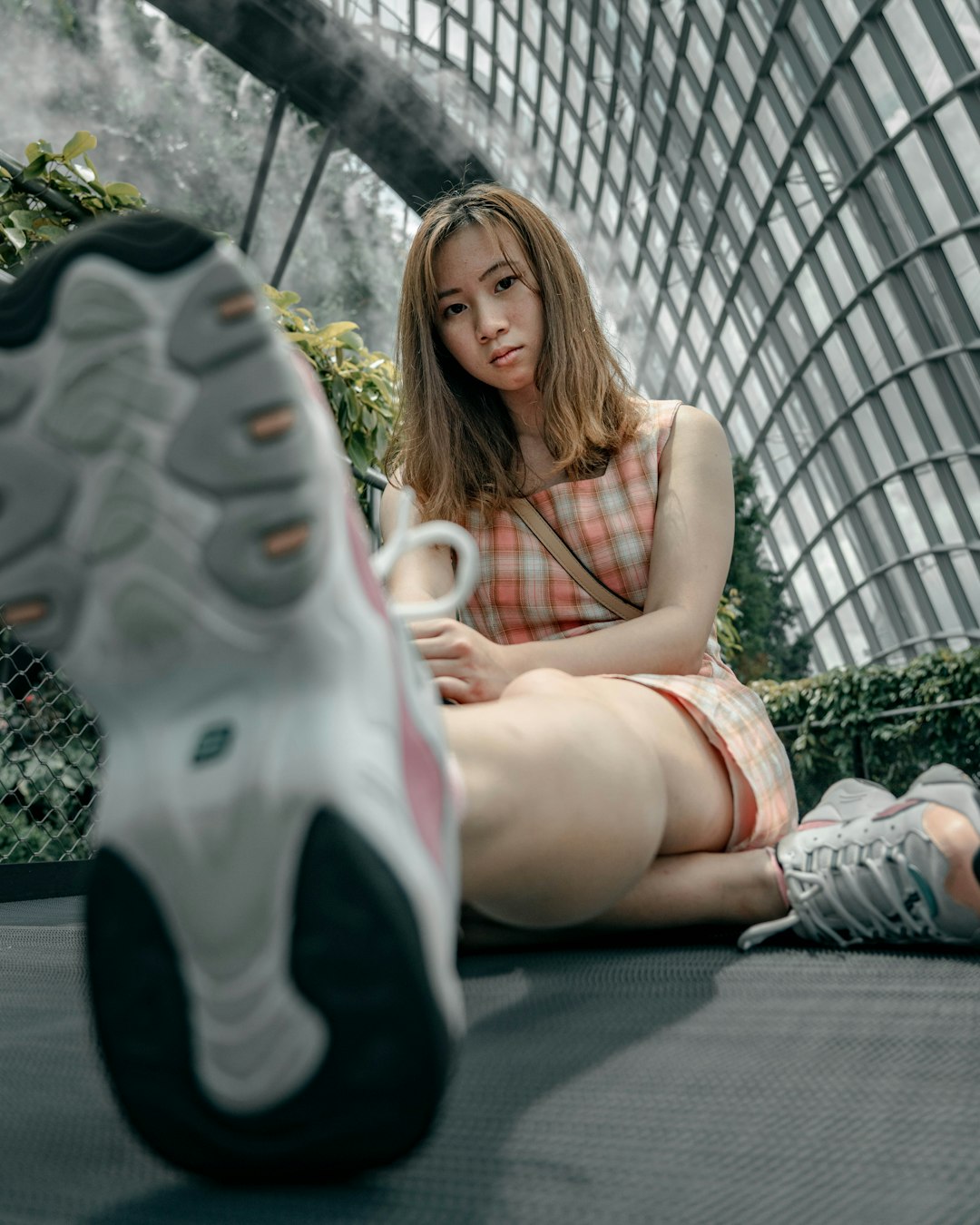 woman in black and white nike sneakers sitting on gray concrete floor